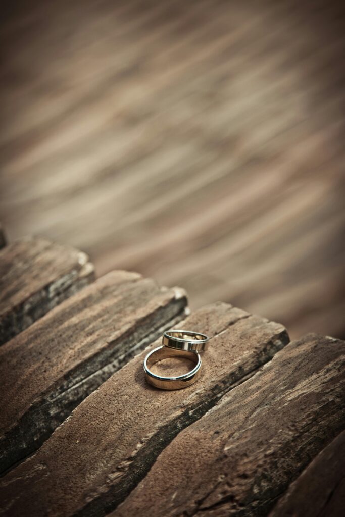 pexels-photo-265916-265916 Close-up of elegant silver wedding rings on a rustic wooden surface, symbolizing love and unity.